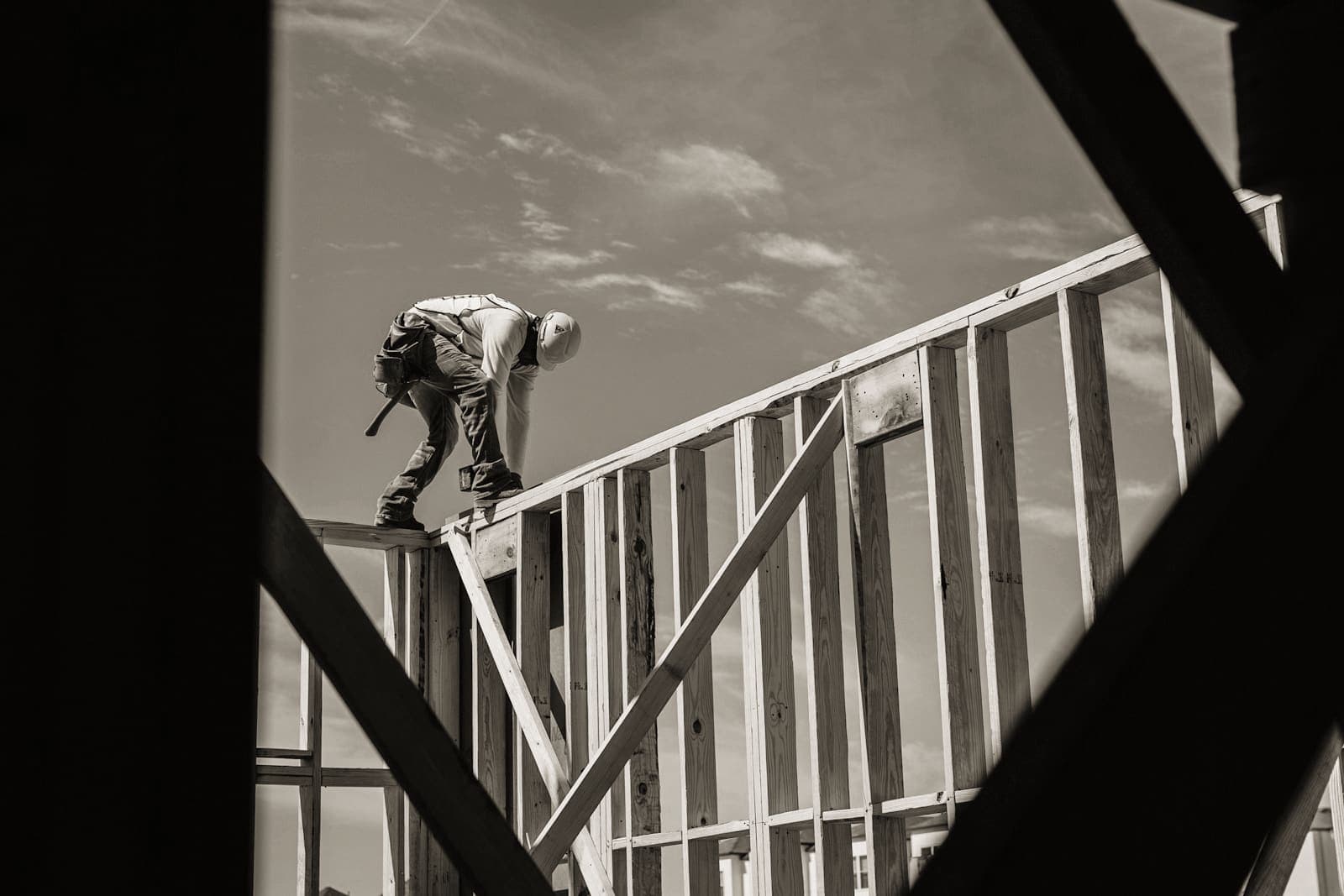 Worker in harness and helmet on a timber frame